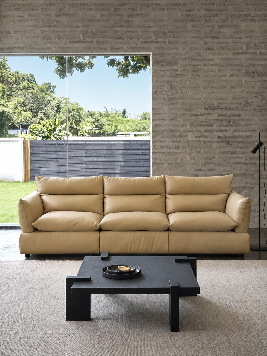 Full-grain leather sofa against a brick wall