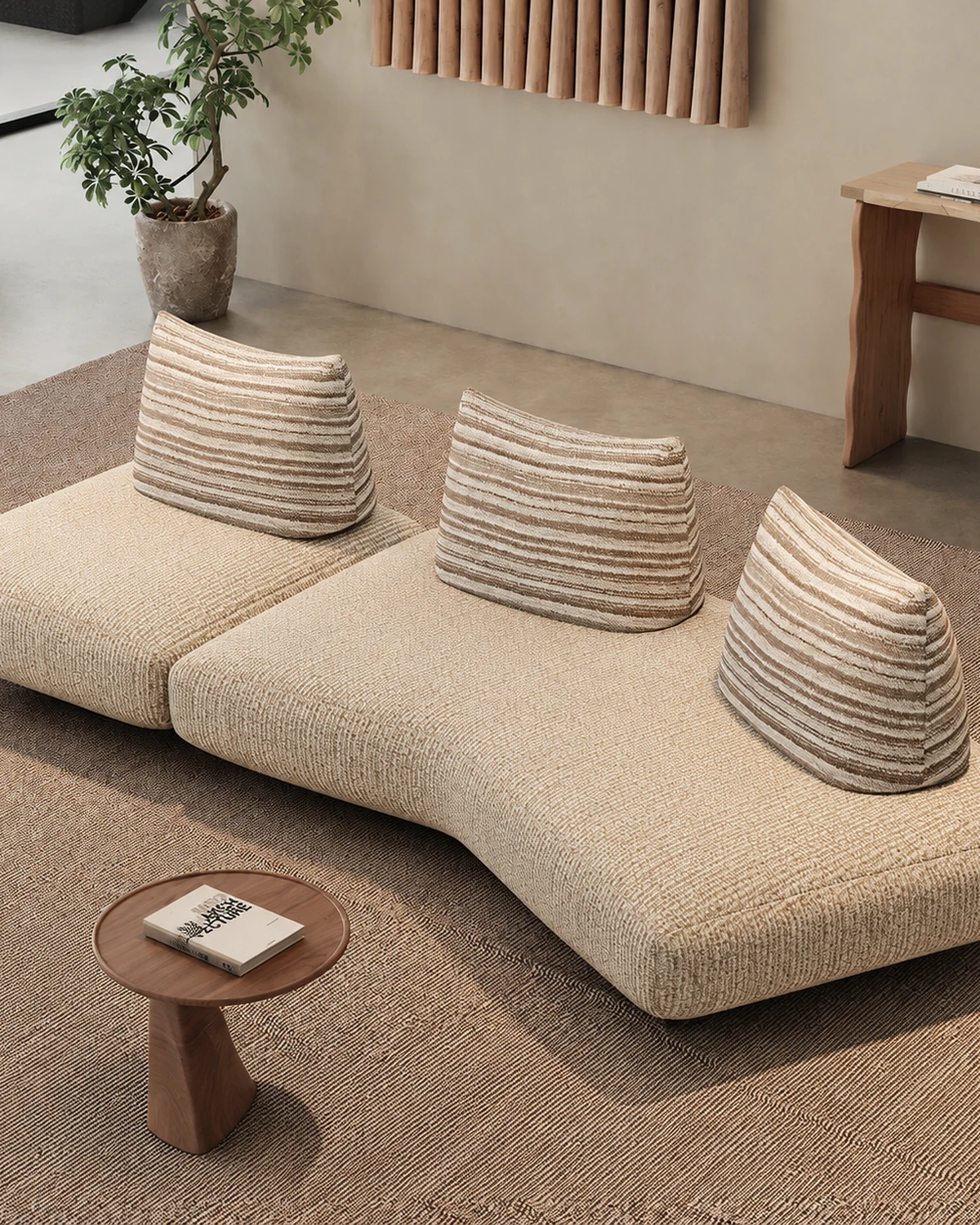 Oatmeal free-form modular sofa with chunky cushions and a round wood side table